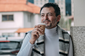 relaxed mature man drinking coffee on the street