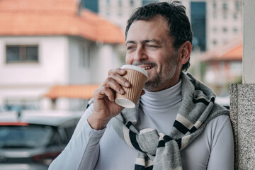relaxed middle aged man drinking take away on the street