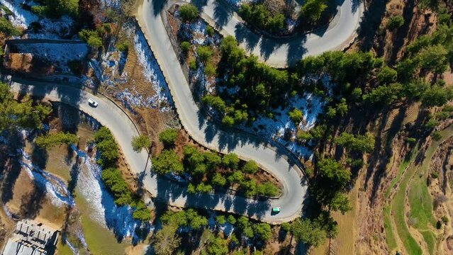Top shot of curvy roads of Malam Jabba Swat Valley in Pakistan during sunny day. Drone view.