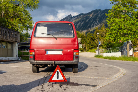 Red car broken down on road with accident at sunny day