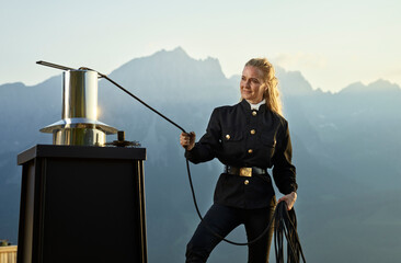 Mature chimney sweeper servicing chimney on rooftop