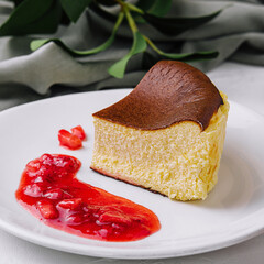 Obraz premium Delectable san sebastian cheesecake slice with strawberry sauce