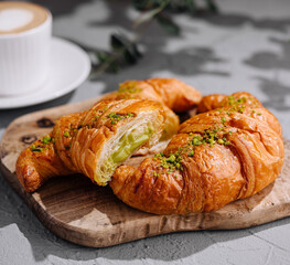 Fresh pistachio croissants and coffee on table