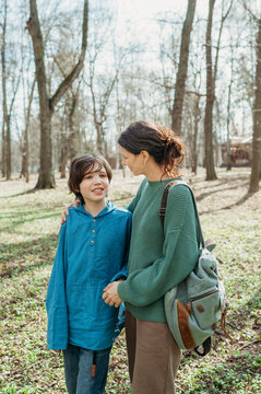 Smiling boy with mother standing at park