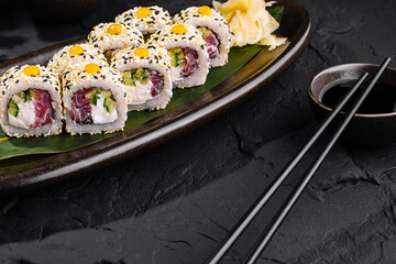 Exquisite sushi roll platter on dark background