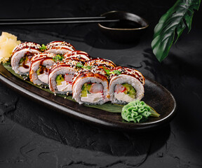 Delicious sushi roll platter on dark slate background