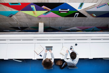 Young university students studying togeter in library, talking, preparing for final exam. Study...
