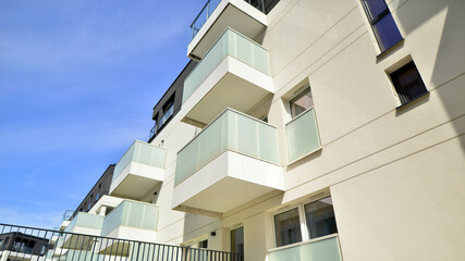 Contemporary residential building exterior in the daylight. Modern apartment buildings on a sunny day with a blue sky. Facade of a modern apartment building