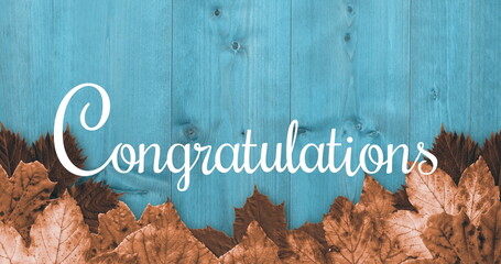 Brown leaves on blue wood with Congratulations written
