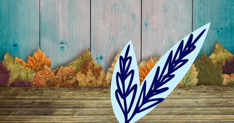 Image of leaves and leaf drawing on wooden background