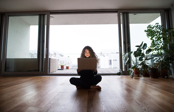 Beautiful woman planning summer vacation abroad, going on trip alone. Working on itinerary on laptop.