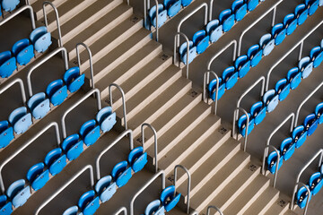 Detailed perspective of symmetrical rows of blue stadium seats, emphasizing the orderly design and repetitive structure of sports venue. 