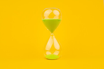 Hourglass on yellow background, time and countdown time limit for urgent work to meet deadlines and...