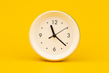 Clock on a yellow background, working with time and planning life, studio photo