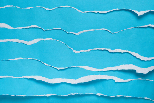 Torn blue paper strips simulating sea waves. Background, texture.