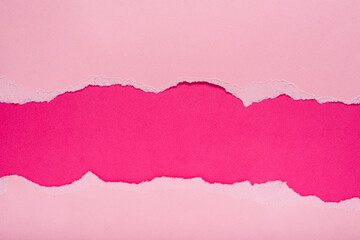 Torn pink paper on dark pink background. Space for text.
