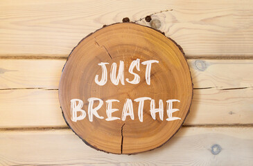 Just breathe and psychological symbol. Concept words Just breathe on beautiful wooden circle....