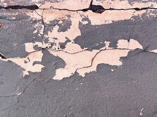 old gray and pink wall with cracks and cracked paint