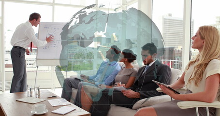 Image of spinning globe against caucasian businessman giving a presentation at office
