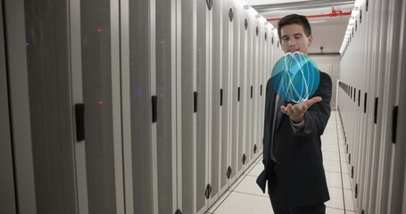 Caucasian colleague in suit holding holographic globe in data center