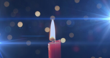 Image of lit candle with flickering spots of light