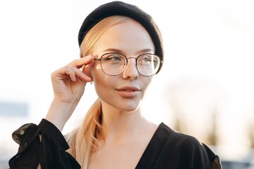 The portrait of a beautiful girl with light daytime makeup, transparent glasses on her eyes which...