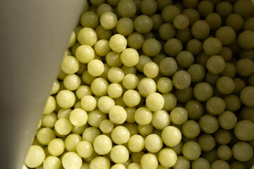 Homeopathic pellets in a container with an opened protective membrane.