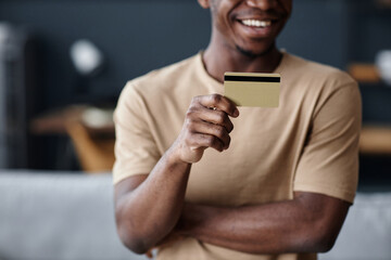 Medium closeup crop shot of hand of cheerful African American man holding bank card