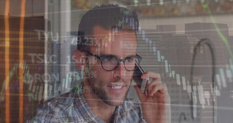 Image of financial data processing over biracial man talking on smartphone against tall building