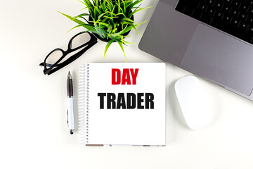 DAY TRADER text on notebook with laptop, mouse and pen