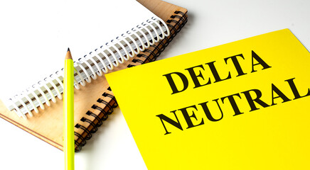 DELTA NEUTRAL text on yellow paper with notebooks