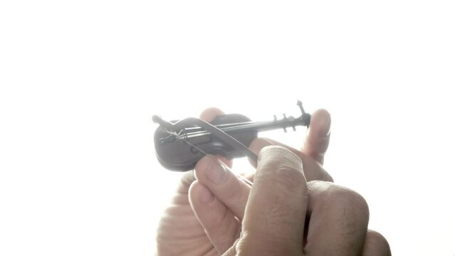 Trying to play the world's tiniest violin: a toy symbolizing irony, mocks others' complaints with its tiny tune, gently highlighting life's absurdities.