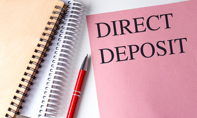 DIRECT DEPOSIT text on pink paper with notebooks