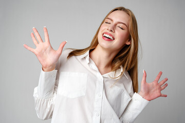 Joyful Young Blonde Woman Smiling against gray background