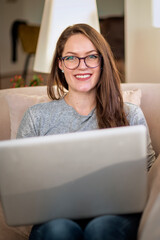 Confident woman sitting at home and using her laptop for work