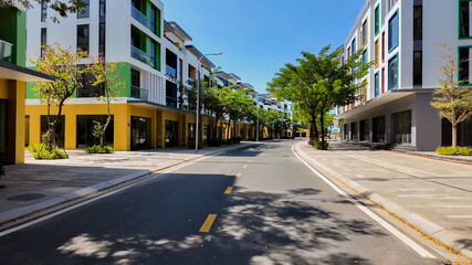 Sunny urban street with modern colorful apartment buildings, empty road with trees, concept of...
