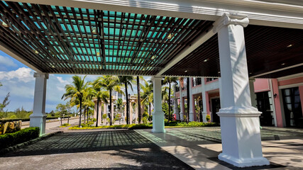 Tropical resort entrance with palm trees and modern architecture, ideal for travel and summer...