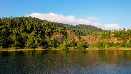 Aerial view of a serene lake by a forest near the coastline, ideal for themes of nature conservation, Earth Day, and outdoor recreation