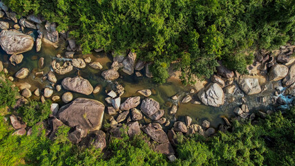 Aerial view of a serene rocky riverbed amidst lush greenery, perfect for themes of nature conservation, Earth Day, and tranquil outdoor landscapes
