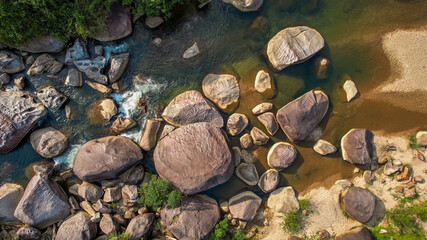 Aerial view of a serene rocky riverbed amidst lush greenery, perfect for themes of nature...