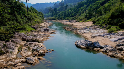 Serene river flowing through a rocky landscape with lush greenery, perfect for nature and travel...
