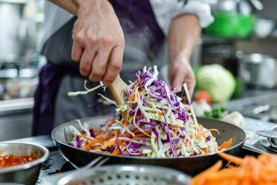 A chef tossing shredded cabbage and carrots with creamy coleslaw dressing