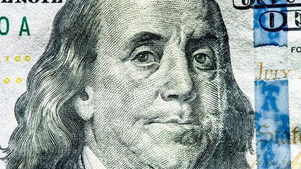 Close-up of Benjamin Franklin's portrait on a US 100-dollar bill, symbolizing economy, finance,...