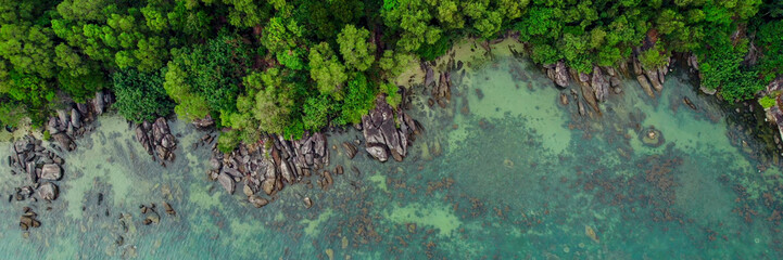 Panoramic aerial view of a tranquil tropical beach with lush greenery and crystal-clear water,...
