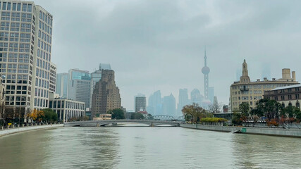 Foggy cityscape of Shanghai with the iconic Oriental Pearl Tower in the distance, reflecting modern urban architecture and travel in China