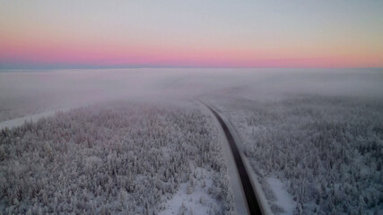 Breathtaking winter sunrise over a frosty forest landscape shrouded in mist, capturing the tranquility of nature during the holiday season Related concepts: winter solstice, Christmas