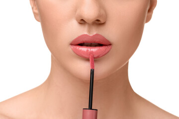 Woman applying lip gloss on white background, closeup
