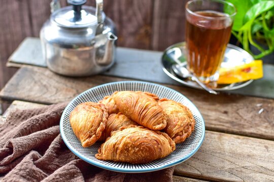 curry puff , karipap with hot tea and teapot  wooden blackground retro style