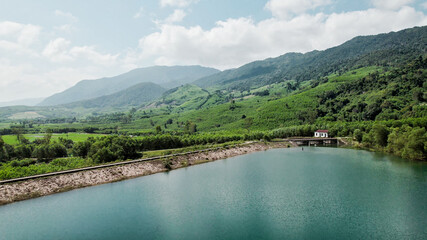 Aerial view of a serene lake surrounded by lush greenery, reflecting clouds overheadideal for Earth Day campaigns and environmental conservation themes