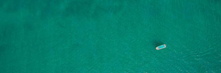 Aerial view of a speedboat in turquoise waters, perfect for travel and summer vacation concepts